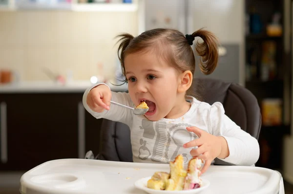 かわいい女の子のケーキを食べる — ストック写真