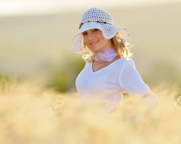Young beautiful woman on golden cereal field in summer — Stock Photo, Image