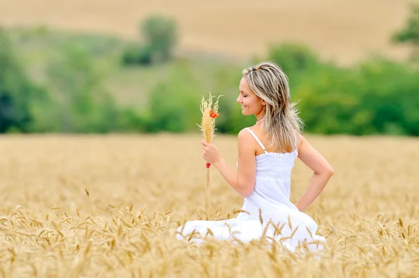 Ung vacker kvinna på fältet i sommar — Stockfoto