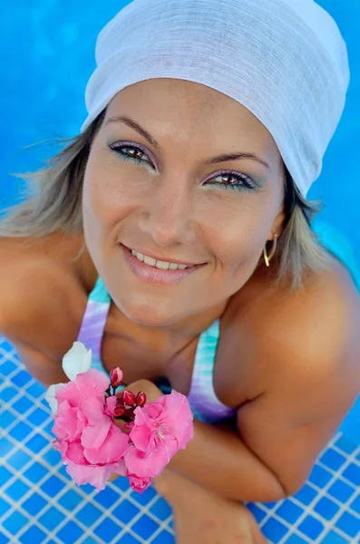 Ung kvinna avkopplande vid poolen — Stockfoto