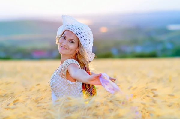 Молода красива жінка на полі золотої пшениці влітку — стокове фото