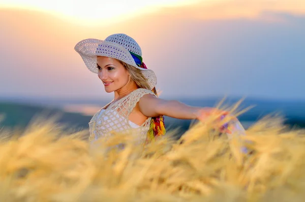 Young beautiful woman on golden wheat field in summer — Stock Photo, Image