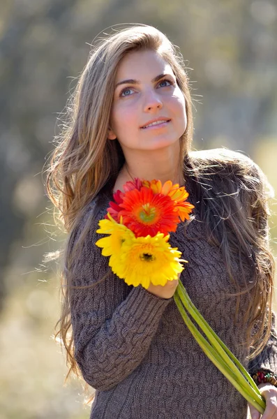 Mooi meisje met kleurrijke bloemen — Stockfoto