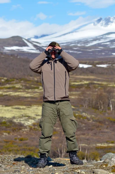 Young man using binoculars outdoor — Stock Photo, Image