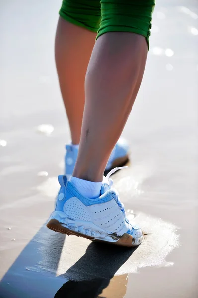 Pies de mujer joven corriendo en la playa — Foto de Stock