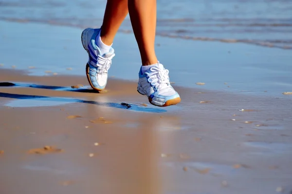 Piedi di giovane donna che fa jogging sulla spiaggia — Foto Stock