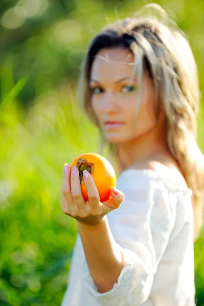 若い女性の持ち株の柿 — ストック写真