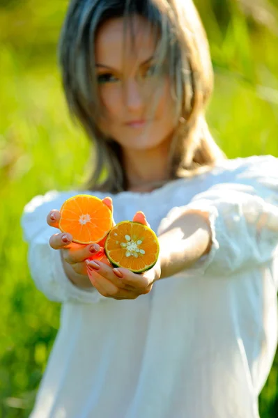 Mujer joven sosteniendo naranja —  Fotos de Stock