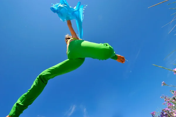 蓝色围巾跳跃的年轻女人 — 图库照片