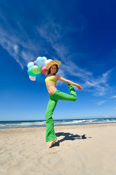 ビーチでカラフルな風船を持つ若い女 — ストック写真