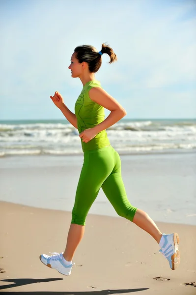 Mujer joven corriendo en la playa —  Fotos de Stock