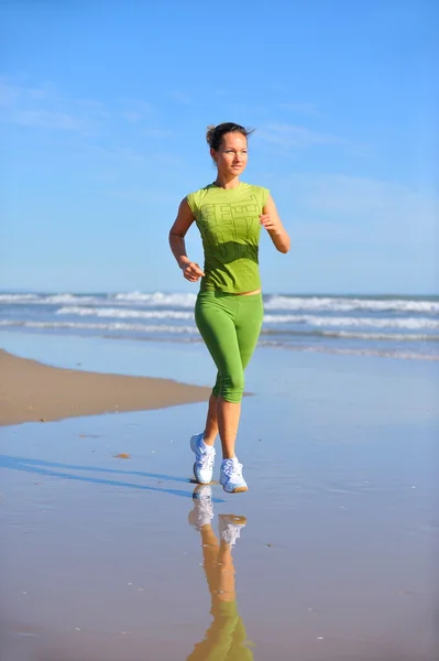 Jeune femme jogging sur la plage — Photo