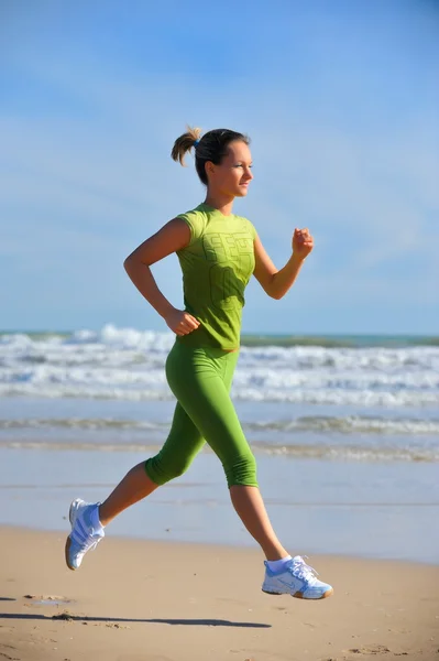 Jeune femme jogging sur la plage — Photo