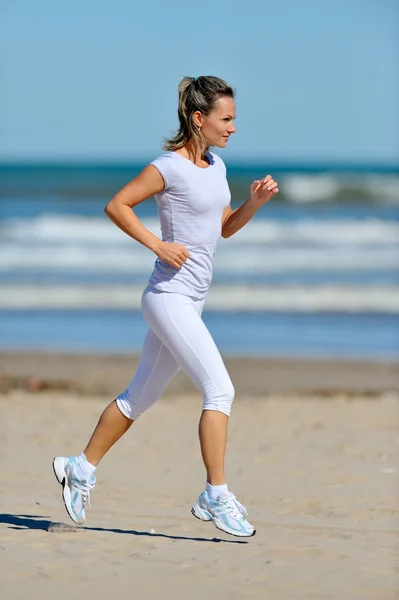 ビーチでジョギングする若い女性 — ストック写真