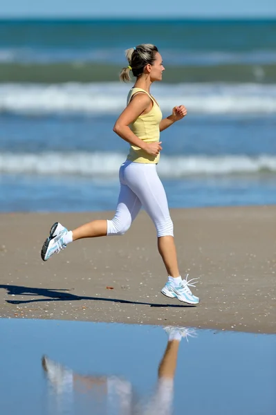 年轻女子在海滩上慢跑 — 图库照片