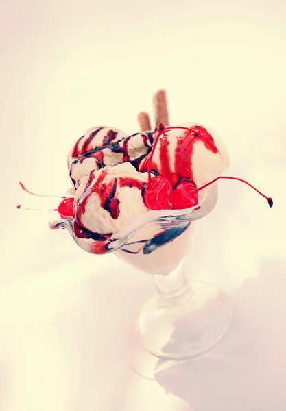 Морозиво в скляній мисці з шоколадним соусом та вишнею — стокове фото