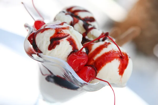 Морозиво в скляній мисці з шоколадним соусом та вишнею — стокове фото
