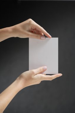 Hands holding white card