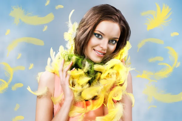 Easter picture of young woman with feathers against blue background — Stock Photo, Image