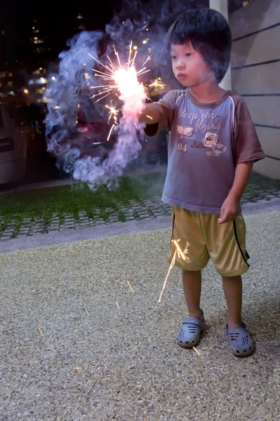 Мальчик с огненными крекерами — стоковое фото