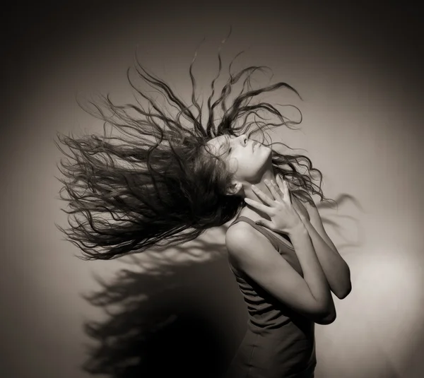 Hodná holka s tekoucí vlasy na šedém pozadí. — Stock fotografie