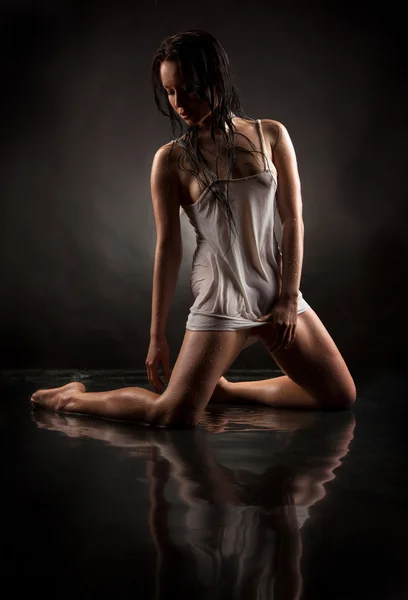 stock image A girl in a wet t-shirt on a black background