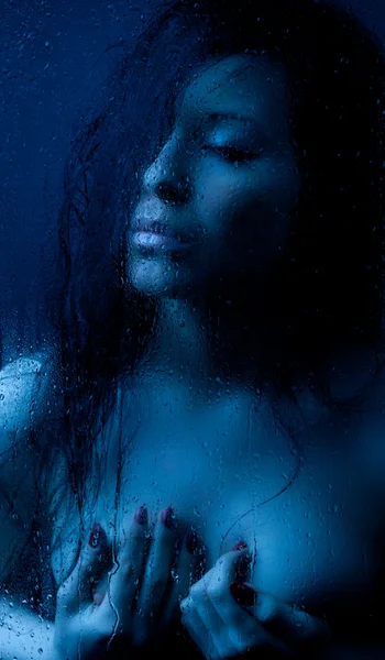 Nahá dívka v mokrém skle na černém pozadí — Stock fotografie