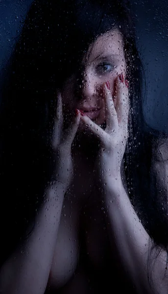 Nahá dívka v mokrém skle na černém pozadí — Stock fotografie