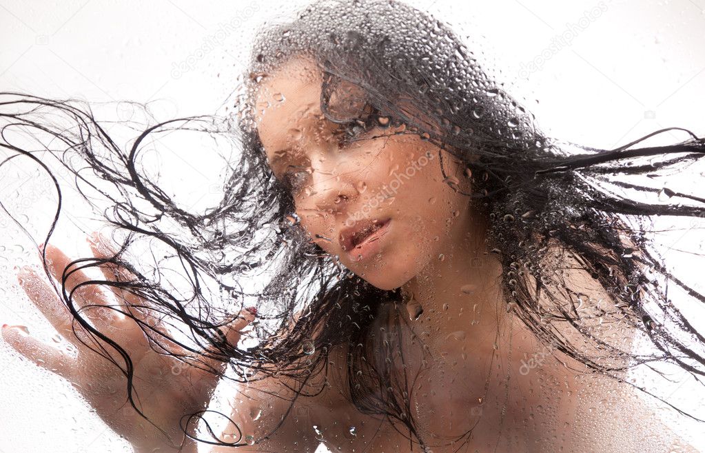 Naked girl in a wet glass on a white background