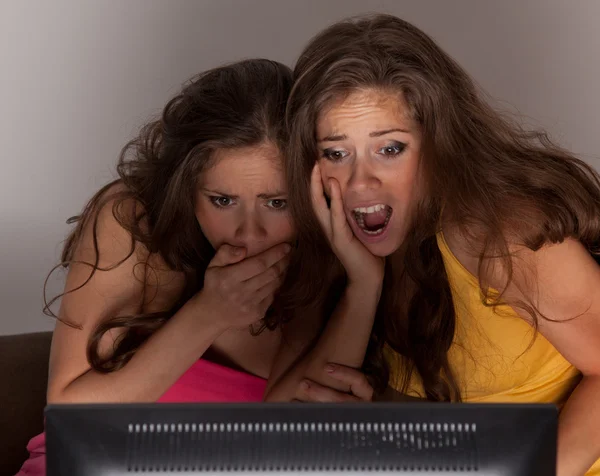 Gemini sisters watching a horror movie on TV — Stock Photo, Image