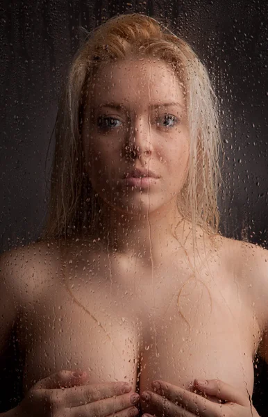 Nackte Mädchen in einem nassen Glas auf schwarzem Hintergrund — Stockfoto