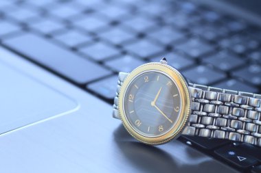 A wrist watch over keyboard clipart