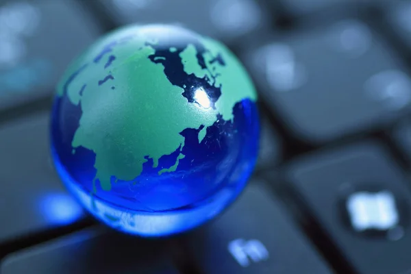 stock image Glass globe over keyboard