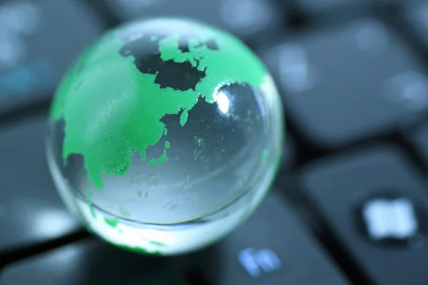 Glass globe over keyboard — Stock Photo, Image