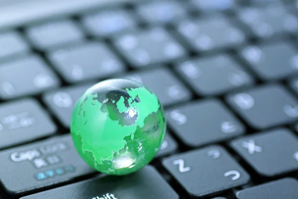 stock image Glass globe over keyboard