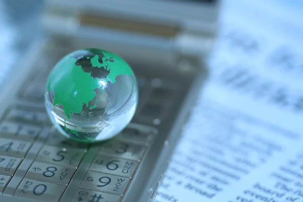 Glass globe over cellphone — Stock Photo, Image