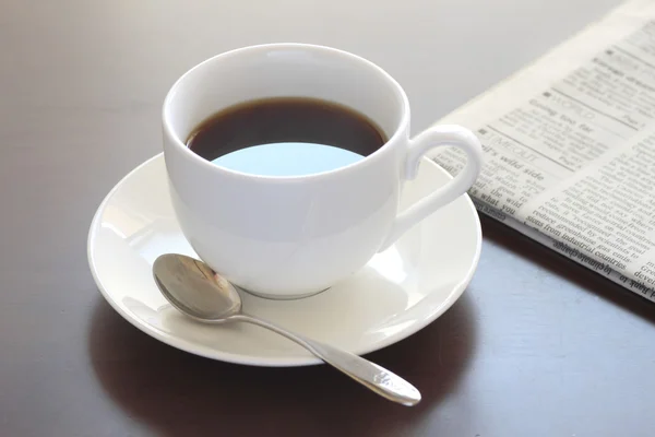 Kopje warme koffie en krant — Stockfoto