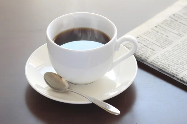 Kopje warme koffie en krant — Stockfoto