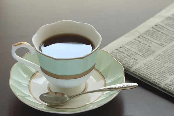 Kopp hett kaffe och tidning — Stockfoto