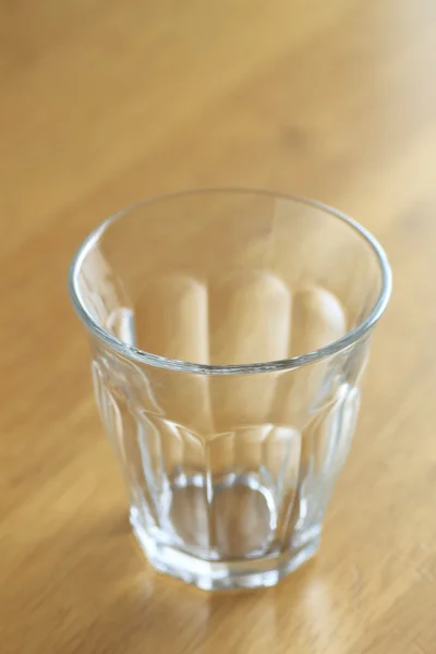 Stock image Glass on wood desk