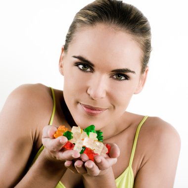 Beautiful brunette caucasian woman on white background handful of jellybeans clipart