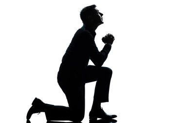 Silhouette man kneeling praying full length clipart