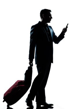 business traveler adam bavul ve telefon ile yürüyor