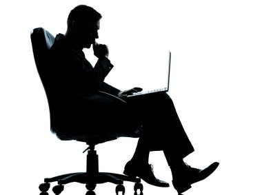 ciddi koltukta oturan bir iş adamı bilgisayar