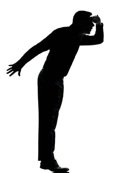 Un uomo d'affari silhouette punta in punta di piedi guardando altrove — Foto Stock