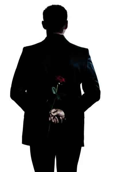 Visão traseira silhueta homem retrato segurando uma flor de rosa — Fotografia de Stock