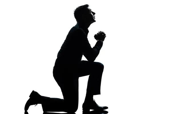 Человек-силуэт, преклоняющий колени, молится во всю длину — стоковое фото
