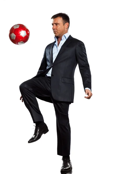Один бизнесмен, жонглирующий футбольным мячом — стоковое фото