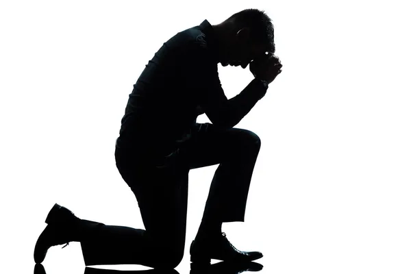 Silueta hombre arrodillado tristeza rezando a lo largo —  Fotos de Stock
