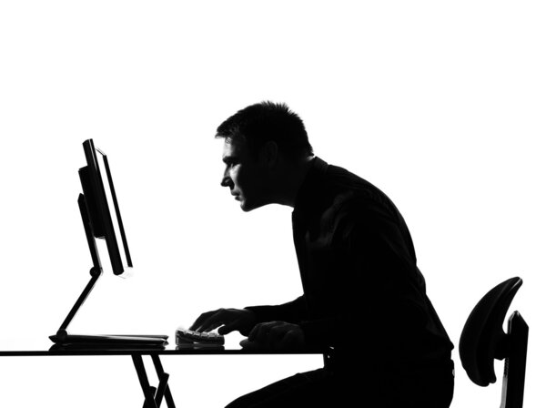 Silhouette man computing staring at the monir